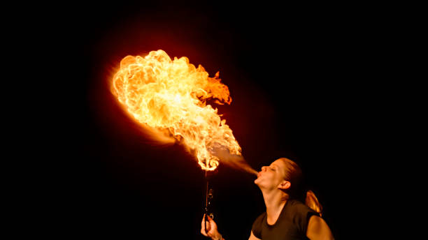 istock Fire breather blowing fire ball from her mouth 1026679718