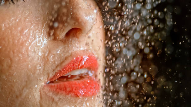 istock Close-up of woman being splashed with water 1026679732