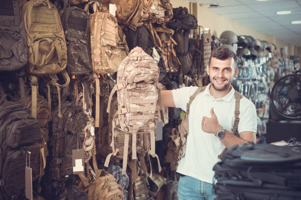 Man with tactical backpacks, giving thumbs up.