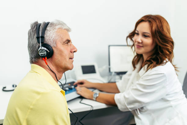Medical hearing examination Senior man at medical examination or checkup in otolaryngologist's office audiologist stock pictures, royalty-free photos & images