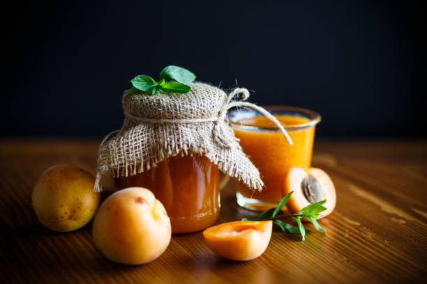 confiture d’abricot douce frais sur une table en bois - preserves jar apricot marmalade photos et images de collection