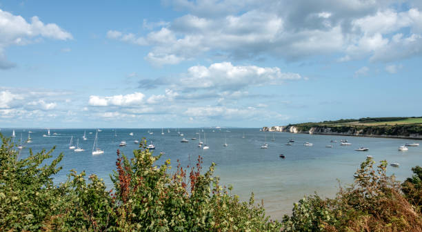 Studland Bay boats by Old Harry Rocks at Studland in Dorset Studland Bay boats by Old Harry Rocks at Studland in Dorset studland heath stock pictures, royalty-free photos & images