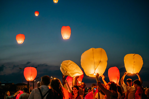 Kiev, Ukraine - June 13, 2018: Group of people launching sky lantern at the festival to the night sky.
