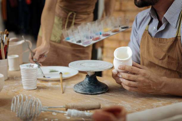 istock Two potters using color paints for decorating their handiworks 1026704942