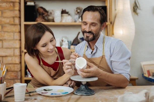 istock Dark-haired potter feeling happy enjoying work with wife 1026705330
