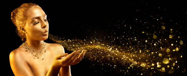 istock Gold Makeup - Fashion Model Blowing Golden Dust 1026712376