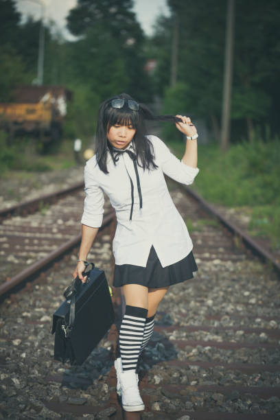 istock asian schoolgirl balancing on a railway 1026712466