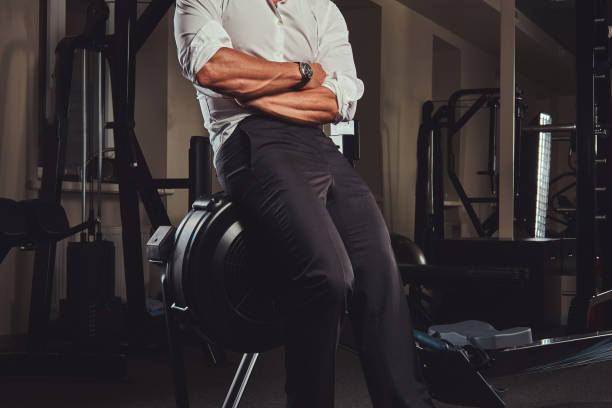 Cropped image of a confident businessman in formal clothes came to a gym for training after a hard day's work. stock photo