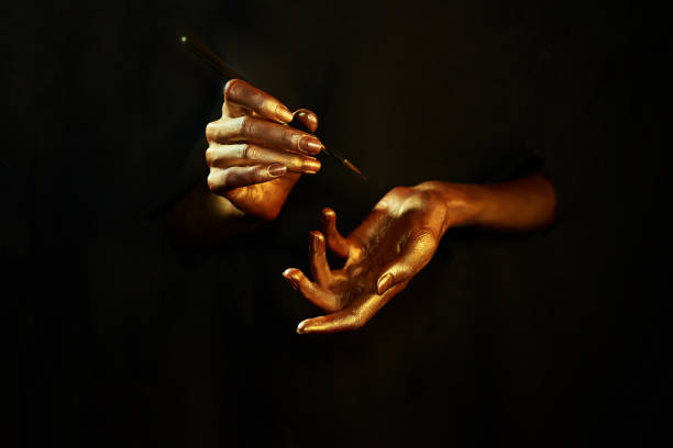 gold hands witn brush on black background