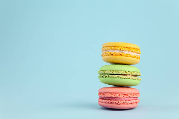 istock Colorful cake macaron or macaroon on blue pastel background. Different types of macaroons. 1026750396