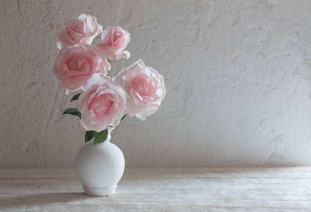 istock pink roses in vase on white background 1026750456