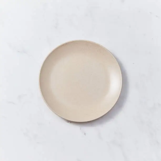 Decorative clay dish, covered with glazed on a gray background with copy space. Can be used for display or montage your products.