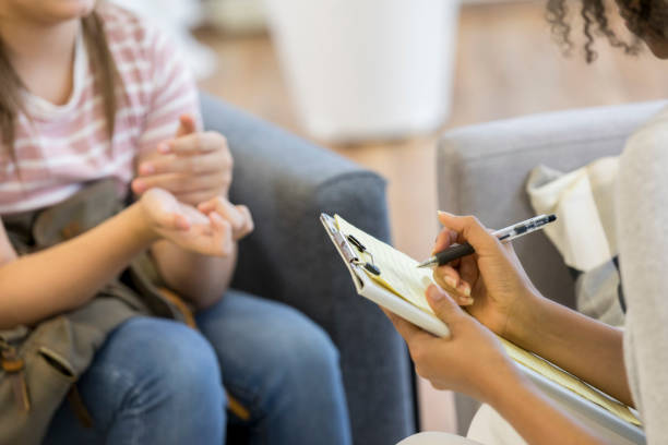 il professionista della salute mentale prende appunti durante la sessione - teenager mental health professional patient psychiatrist foto e immagini stock