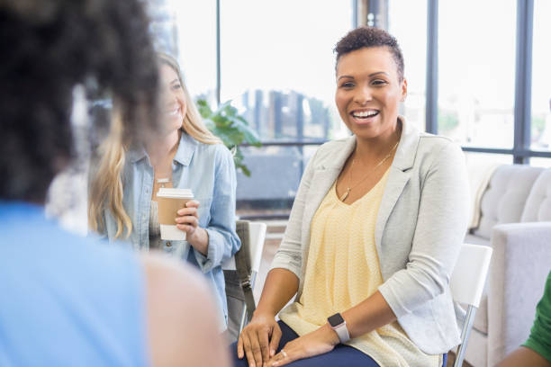 istock Mid adult woman discusses something during group therapy 1026754472