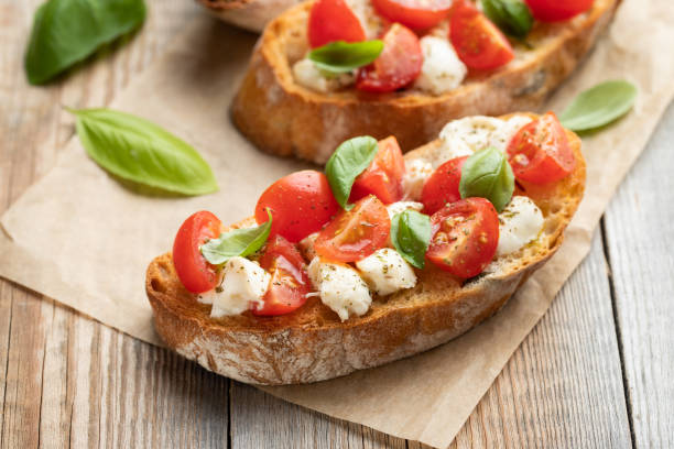 istock Bruschetta with tomatoes, mozzarella cheese and basil on a old rustic table. Traditional italian appetizer or snack, antipasto 1026777074