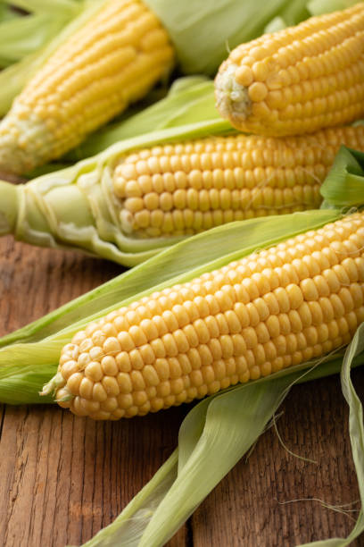 istock Fresh corn on cobs on rustic wooden table, closeup 1026777262