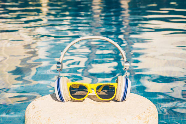 atributos de las vacaciones de verano - gafas de sol y auriculares - en el fondo de la piscina - tourist resort audio fotografías e imágenes de stock