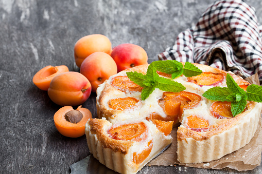 Homemade  cheese cake with apricot on wooden table