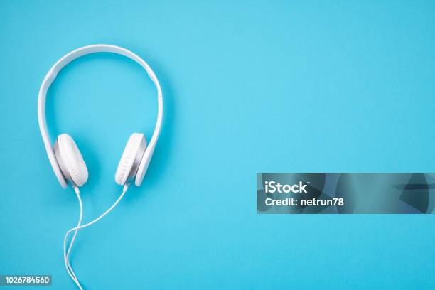 White Earphones On Blue Background Stock Photo - Download Image Now - Headphones, Blue Background, Listening