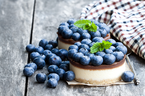 Two mini  chocolate cheesecake with fresh blueberry on wooden table