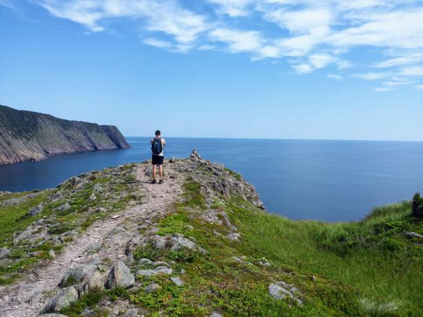 Man taking a photo on his camera of the open and calm atlantic ocean along the sugarloaf trail in Newfoundland and Labrador, Canada Man taking a photo on his camera of the open and calm atlantic ocean along the sugarloaf trail in Newfoundland and Labrador, Canada st. johns newfoundland photos stock pictures, royalty-free photos & images