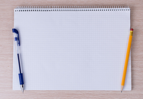 Office tools and stationery supplies on wooden table.Top view, space for text cage notebook