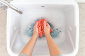 Female hands washing color clothes in sink
