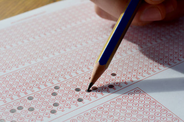 istock Hand with pencil filling out answers on exam test answer sheet 1026814258