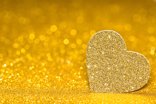 Shining heart on a golden radiant background. Glitter shine with 3d shape.