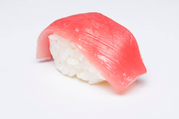 Close-up of traditional japanese sushi nigiri with a slice of tuna fish on white background.