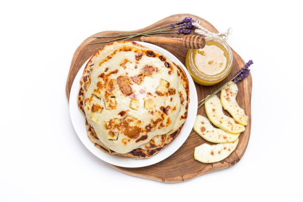 Pancakes with apple and cinnamon Top view of an appetizing pancakes with honey jar and sliced apple decorated with dried lavender flowers. apple cinnamon pancake stock pictures, royalty-free photos & images
