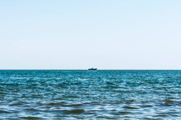 istock blue sea with waves, far away on a horizon line floating ship, nature abstract background 1026820578