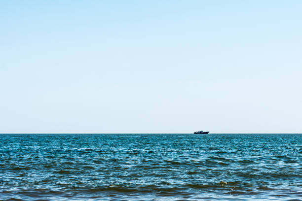 istock blue sea with waves, far away on a horizon line floating ship, nature abstract background 1026820584