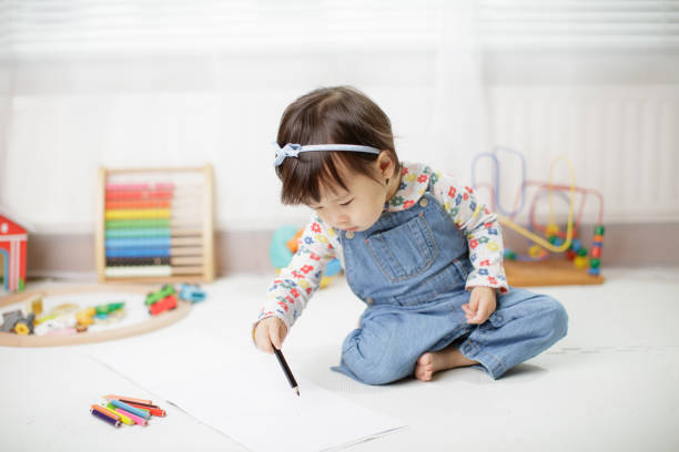 istock baby girl drawing at home 1026831084