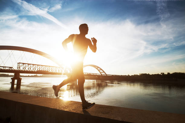 istock Fitness training outdoors. Handsome man working exercises in early morning with sunrise. Muscular man training outside. Sunny fitness morning. 1026831780