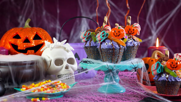 istock Halloween candyland drip cake style cupcakes in party table setting 1026843352