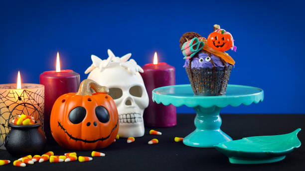 istock Halloween candyland drip cake style cupcakes with candy on blue background 1026843498