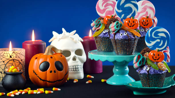 istock Halloween candyland drip cake style cupcakes with candy on blue background 1026845272