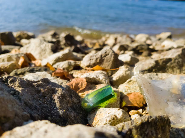 istock Broken glass in the rocks on the beach is dangerous 1026845974
