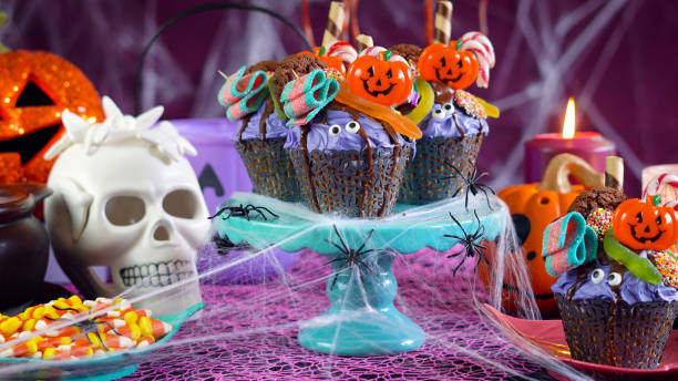 istock Halloween candyland drip cake style cupcakes in party table setting 1026846048