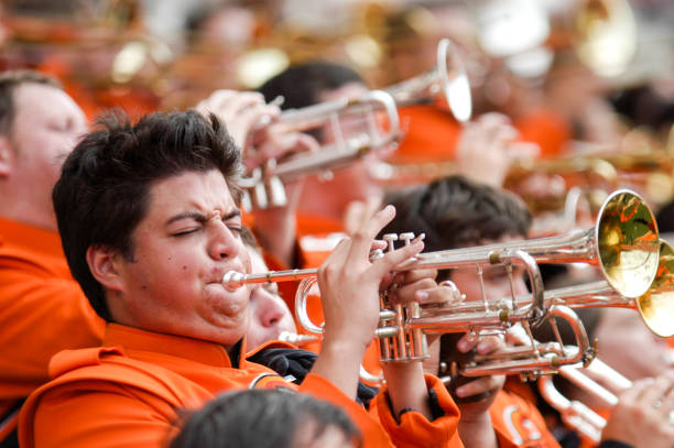 trombettista durante l'esibizione della band in marcia sul campo di calcio - jazz music trumpet valve foto e immagini stock