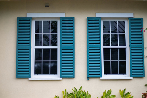 Steel storm shutters for hurricane protection of house windows. Protective measures before natural disaster in Florida.