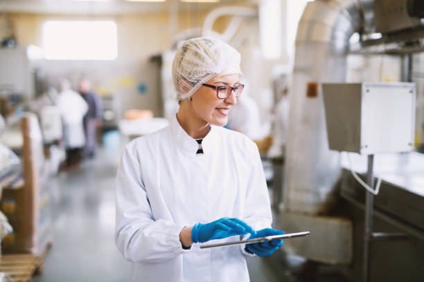 istock Smiley female worker in sterile clothes using tablet and checking how production line is working. 1026858958