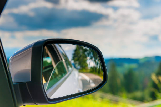 istock car mirror with reflection of a beautiful landscape in it, close-up 1026870792