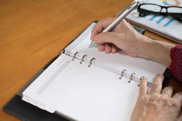 istock woman hand with pen writing note on notebook at office 1026871134