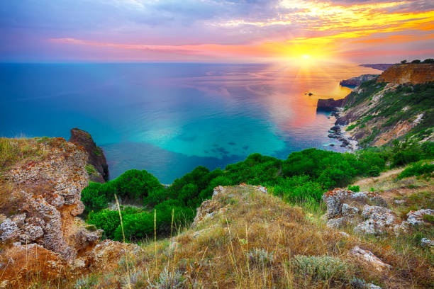 istock Dramatic sunset at cape Fiolent with bushes grass and rocks at foreground. 1026880674