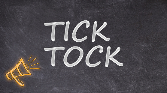 Tick tock written on blackboard yelled by megaphone