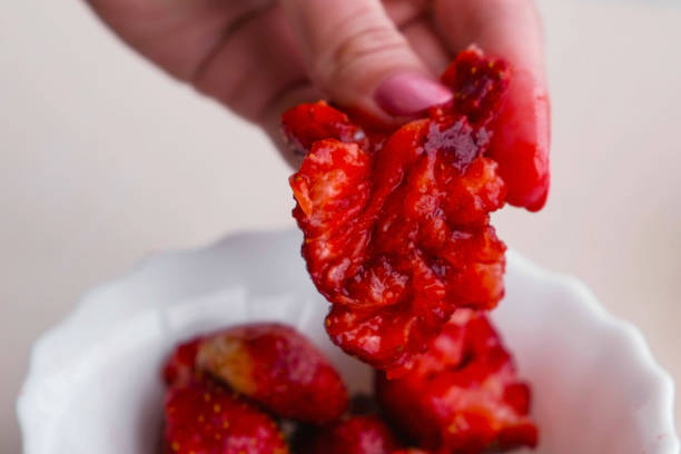 istock Woman kneads strawberry in her hand making jam. 1026889904