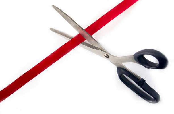 Scissors cutting red ribbon, opening ceremony concept