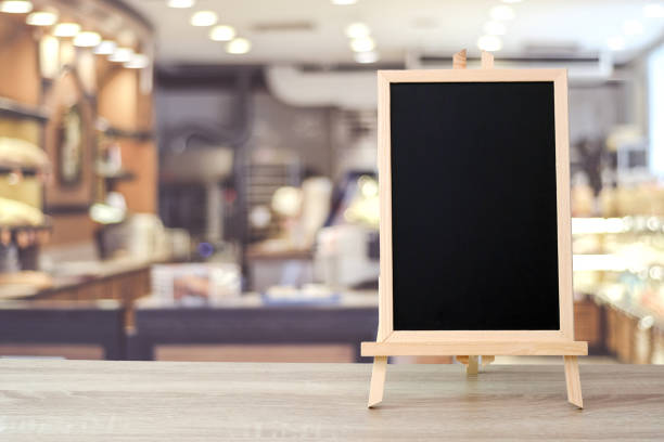 istock Blank chalkboard standing on table over blur cafe with bokeh background, space for text, mock up, product display montage 1026910018